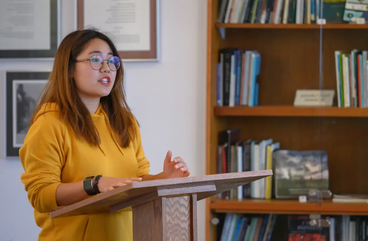 A student reading a poem at a podium