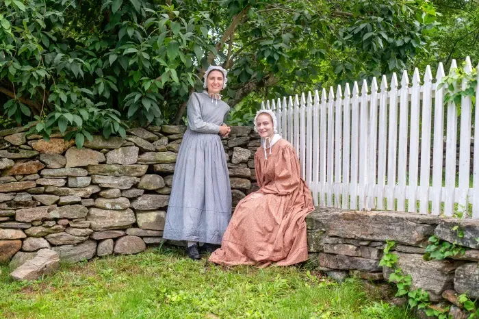 Two students dressed in clothes from the 1830s, interning as costumed interpreters at Old Sturbridge Village.